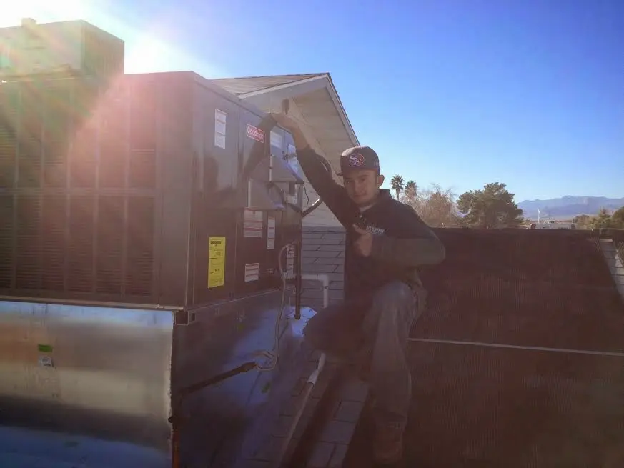 HVAC technician performing HVAC Inspection on a rooftop unit in Spotswood